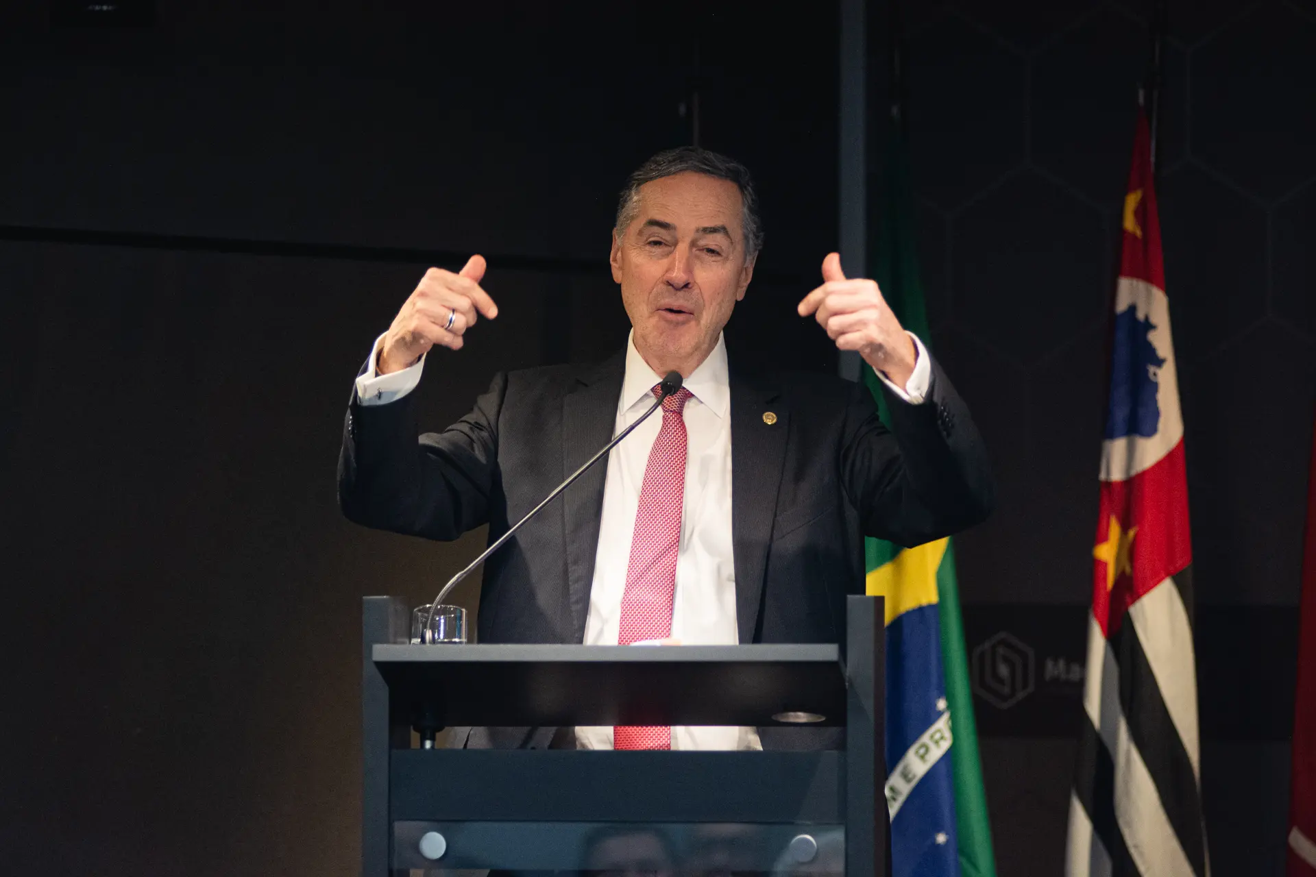 Palestrante discursando em púlpito durante evento corporativo
